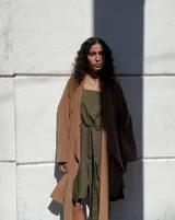 Collar con dije circular irregular de alpaca y plata 925, con hilo de algodón natural.