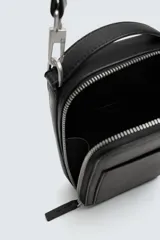 Bandolera negra con textura grabada, compartimento principal con cierre de cremallera, bolsillo interior plano, bolsillo frontal plano y asa de hombro ajustable y extraíble.
