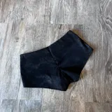 Short negro de tiro alto con detalle de argollas metálicas en la cintura.