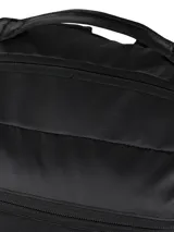 Mochila negra de estilo utilitario con compartimento principal acolchado para computador y múltiples bolsillos organizadores interiores. Presenta detalles en amarillo vibrante en las correas de compresión laterales y un parche con el logotipo de CAT en la parte inferior frontal.