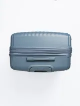 Valija rígida de 28 pulgadas color celeste con diseño de líneas diagonales en relieve. Cuenta con manija retráctil, cuatro ruedas con giro de 360°, cierre con combinación y manija lateral. Interior forrado con divisor y bolsillo de red.