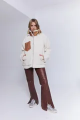 Pantalón de cuero marrón chocolate, de tiro alto, corte recto con leve flare y aberturas en el ruedo. Presenta costuras marcadas y trenzado lateral.