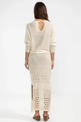 Falda midi color crema, tejida a crochet con aberturas en la parte inferior.