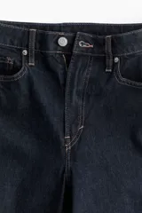 Jean de calce curvy, color azul oscuro, de tiro alto y pierna ajustada. Confeccionado en denim de algodón levemente elástico y con diseño de cinco bolsillos.