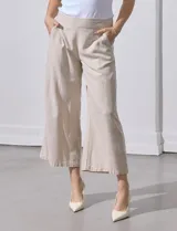 Pantalón crop de lino estampado con hojas en tonos verdes y azules. Tiene pretina trasera elastizada y bolsillos delanteros.