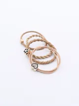 Set de tres gomitas para el pelo color beige, una con forma de corazón con strass, otra con forma de flor y otra con detalle de cubo dorado.