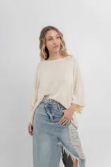 Sweater color crudo de tejido liviano con textura semi traslúcida, escote redondo y mangas amplias estilo murciélago.