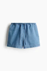 Short de denim azul claro, con cintura elástica y cordón ajustable. De corte holgado con bolsillos laterales y bajo recto con abertura lateral corta.