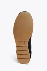 Zapatillas deportivas negras con detalle de estampado animal en la parte trasera, suela color caramelo y ajuste con cordones.