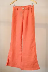 Pantalón de lino color coral, de corte palazzo con aberturas laterales en el ruedo.