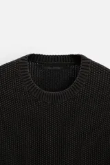 Sweater azul de punto con textura, corte holgado, cuello redondo y mangas largas con puños acanalados.