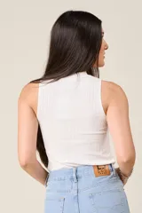 Musculosa blanca de hilo con cuello redondo y detalle de cadena dorada.
