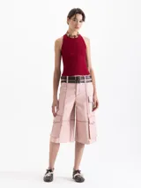 Top de punto acanalado color negro, ajustado al cuerpo y de largo por encima de la cadera. Presenta cuello redondo cerrado y breteles cruzados en la espalda. Confeccionado en hilado frío.