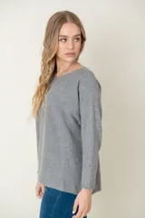 Sweater de lana color beige, de corte holgado y mangas largas.