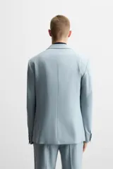 Blazer slim fit color celeste confeccionada en tejido con viscosa. Cuello con solapas de muesca. Manga larga acabada en puño con detalle de botones. Bolsillo de vivo en pecho y de solapa en cadera. Detalle bolsillo interior. Bajo con aberturas en espalda. Cierre frontal con botones.
