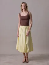 Falda midi color amarillo pálido, de algodón, con pretina ancha elastizada y forro interno a tono.