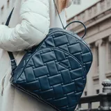 Mochila azul acolchada de símil cuero soft, con diseño entretejido y logo XL Extra Large al frente.