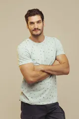 Remera celeste con estampado de figuras geométricas en tonos naranja y verde.