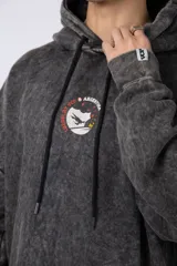 Buzo canguro color ocre con capucha y cordones negros, de corte oversize y confeccionado en tela de algodón friza con teñido artesanal y estampa circular en el pecho.