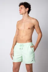 Short de baño verde agua con efecto desgastado, cintura elástica con cordón ajustable y bolsillos laterales.