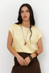 Blusa de manga 3/4 y cuello redondo, color amarillo pálido con acabado satinado/laminado.