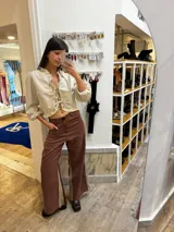 Pantalón sastrero color beige de lino, corte recto y tiro alto, con bordado de caballo en el bolsillo trasero.