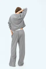 Pantalón deportivo gris de corte recto, con cintura elástica y bolsillos laterales.