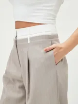 Pantalón de vestir color visón con finas rayas verticales, tiro alto y corte palazzo.