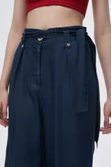 Pantalón celeste de tiro alto, corte ancho y lazo en la cintura.