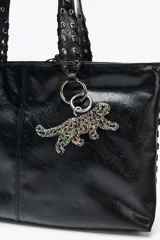 Llavero con forma de leopardo elaborado en abalorios con combinaciones de color negro, dorado y plateado.