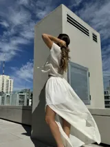 Conjunto de top negro con tirantes finos y falda larga blanca con tajo lateral.