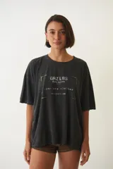 Remera negra holgada de algodón con estampa frontal con texto 'GRZ LBS Daily Luxury Timeless Clothes Collection'.