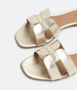 Sandalia plana de cuero sintético color negro, con puntera cuadrada y tiras anchas cruzadas en el empeine.