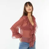 Blusa de manga larga color rojo con volantes en el escote y en los puños.