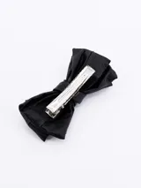 Pinza para el pelo con forma de moño de cuero sintético color negro.