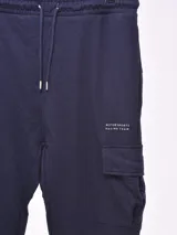 Pantalón de jogging azul marino con cintura elástica ajustable con cordón, bolsillos laterales y bolsillos cargo con solapa en los muslos.