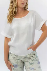 Blusa gris lavanda metálico de corte recto y fluido, con mangas cortas con vuelta, escote redondo y abertura en la espalda.