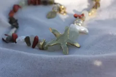 Collar de alpaca con cuentas de labradorita, jaspe rojo y cuarzo lima. Incluye una estrella de mar realizada a mano y una perla de río natural.