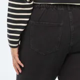 Pantalón de jean negro, corte mom, con cintura elástica y bolsillos delanteros y traseros.