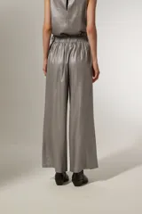 Pantalón ancho de tiro alto color beige metalizado, confeccionado en lino y viscosa, con lazo para ajustar en la cintura.