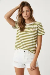 Remera de manga corta con estampado a rayas horizontales en tonos verde oliva y blanco. Tiene un pequeño bordado de una flor rosa en el pecho.