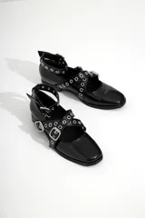 Chatas de cuero color negro con tiras cruzadas y tachas plateadas.