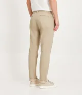 Pantalón de vestir azul marino, de corte recto, con bolsillos laterales y traseros. Se ajusta a la cintura con cinturón de cuero marrón.