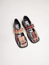 Zapato guillermina con estampado a cuadros en tonos beige, rojo y negro. Tiene punta cuadrada, correa de cuero fina y regulable con hebilla color bronce, planta capellada cosida a la suela y taco de 4cm de altura.