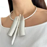 Collar rígido plateado con tres colgantes geométricos texturizados.