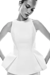 Top blanco sin mangas, con cuello halter y bajo con pliegues. Cierre trasero con cremallera oculta.