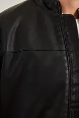 Campera de cuero ecológico color negro, con cuello mao y cierre frontal con cremallera metálica al tono.