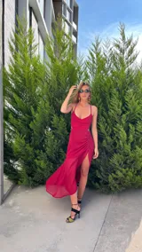 Vestido largo color marrón, con escote corazón, tirantes finos y falda con frunces laterales y tajo frontal.