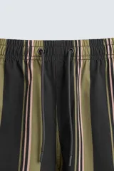 Bañador corto de tejido técnico con rayas verticales en tonos negro, verde oliva y rosa. Cuenta con cintura elástica ajustable con cordón, bolsillos laterales y trasero.