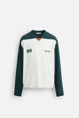 Camiseta de manga larga con cuello pico y corte relaxed fit. Diseño color block en blanco y verde con bordado de la palabra 'Saint Frederic' y el número '80' en el frente.